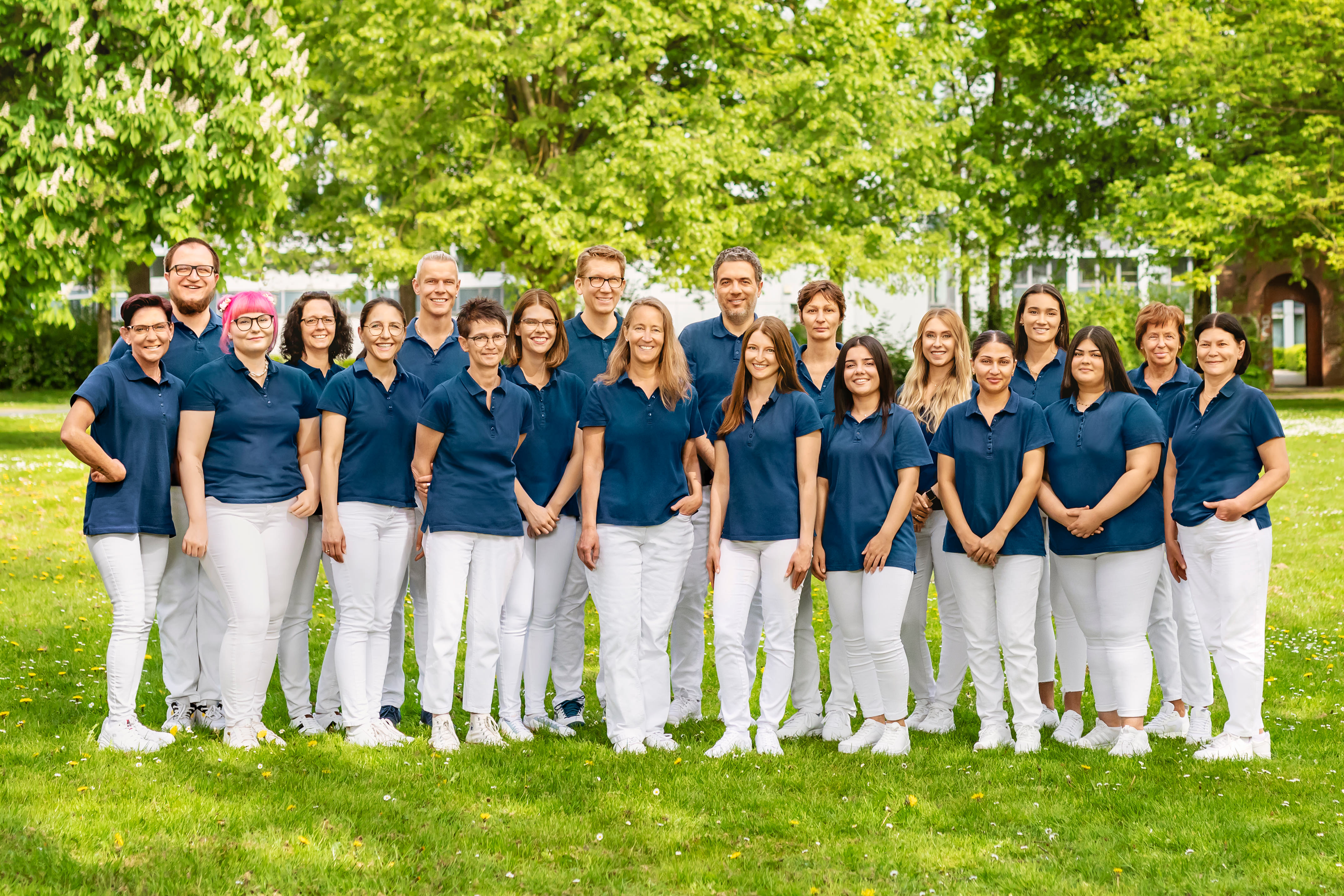 Team der Kieferorthopädischen Praxis Dr. Blümchen in Bielefeld, Gruppenfoto im Grünen