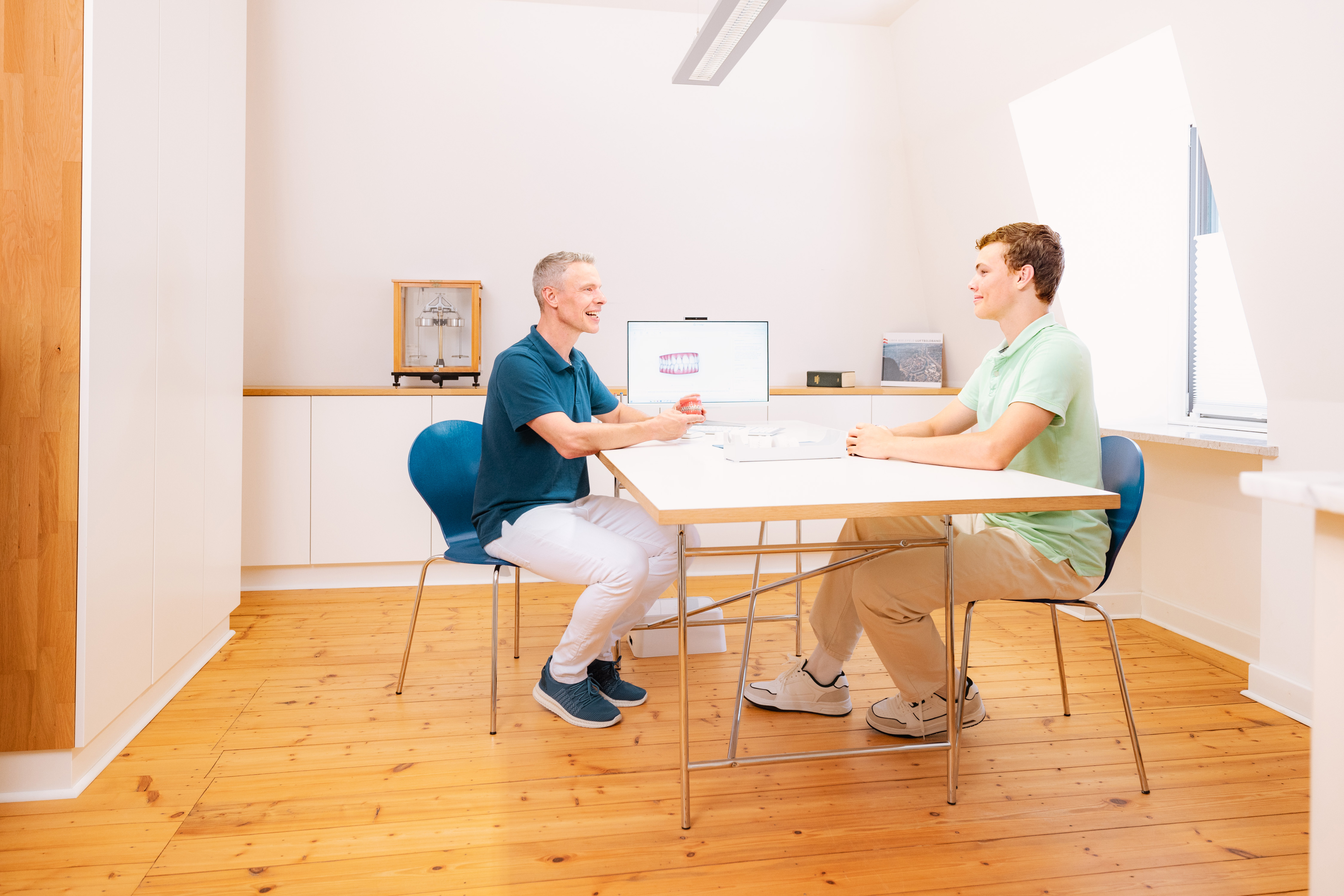 Besprechungsraum im 1. Obergeschoss der kieferorthopädischen Praxis Dr. Blümchen in Bielefeld, in dem Beratungsgespräche mit Patientinnen und Patienten stattfinden – ruhig und getrennt vom Praxisbetrieb im Erdgeschoss.
