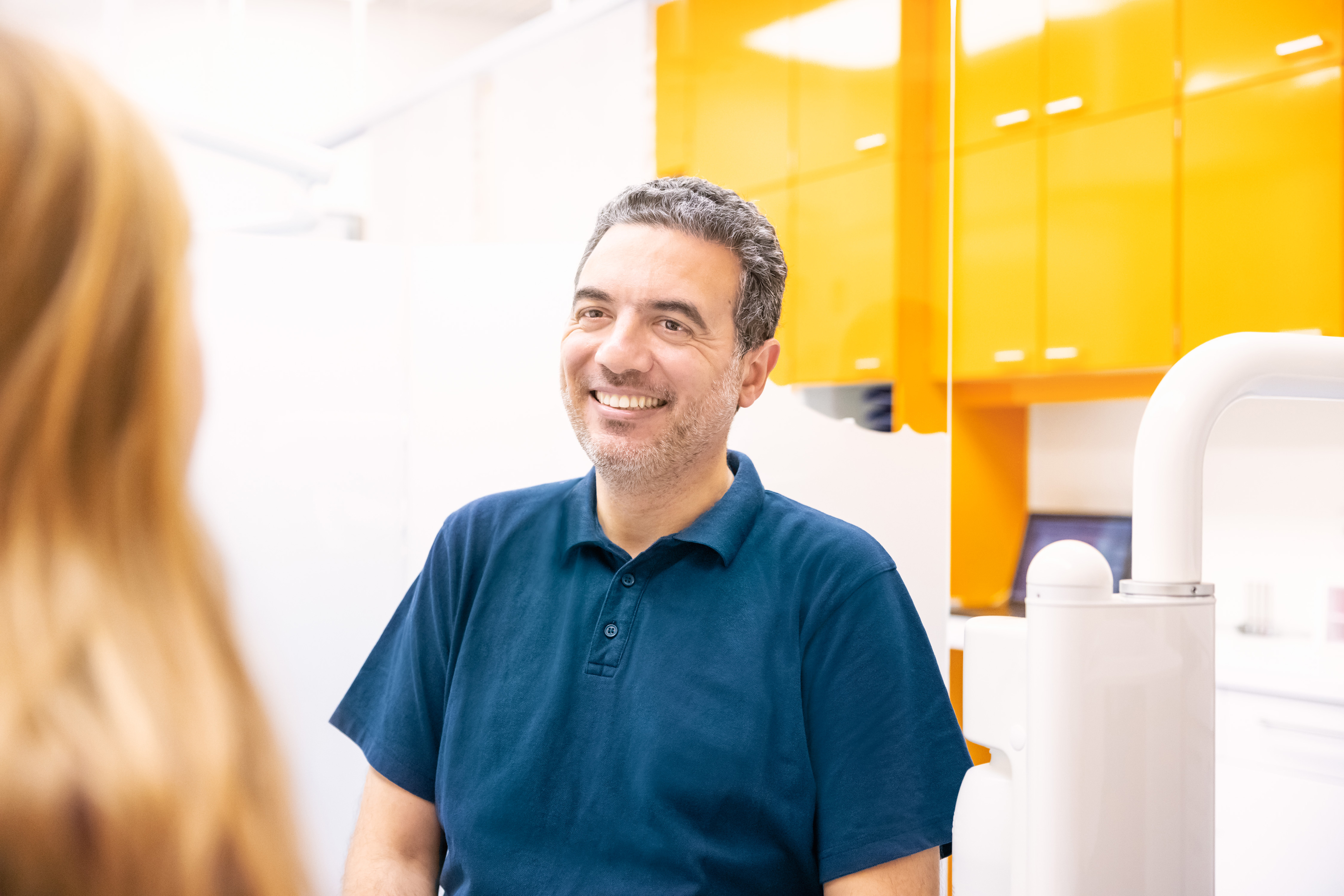 Slim Ben Gamra, Zahnarzt mit Tätigkeitsschwerpunkt Kieferorthopädie, im Gespräch mit einer Patientin während eines Termins in der Praxis.